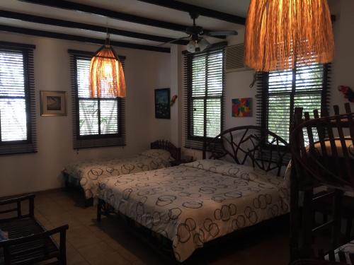a bedroom with two beds and windows at Hostería Ecológica El Faro in Salinas