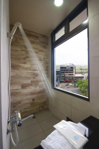 a bathroom with a shower with a window and a shower at Yixiang Spring Travel in Jiaoxi