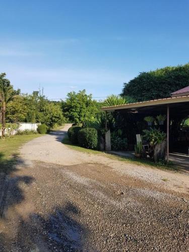a house with a gravel road next to a building at สบาย สบาย รีสอร์ท in Ban Khao San