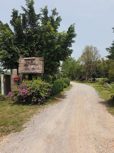 a dirt road with a sign on the side at สบาย สบาย รีสอร์ท in Ban Khao San