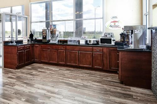 a kitchen with wooden cabinets and a counter top at Super 8 by Wyndham Elk City in Elk City
