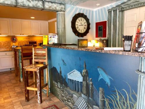 eine Küche mit einer Theke mit einer Uhr an der Wand in der Unterkunft Atlantis Inn - Tybee Island in Tybee Island