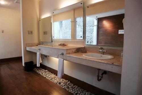 a bathroom with a sink and a large mirror at The Lagoon Bali Pool Hotel and Suites in Legian
