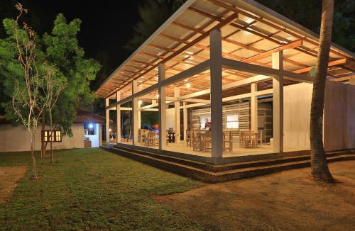 a house with a large glass extension at night at Arugambay PodBay in Arugam Bay