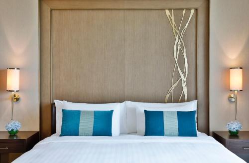 a bed with a white comforter and pillows at Anantara Eastern Mangroves Abu Dhabi in Abu Dhabi
