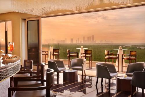 a bar with chairs and a view of the city at Anantara Eastern Mangroves Abu Dhabi in Abu Dhabi