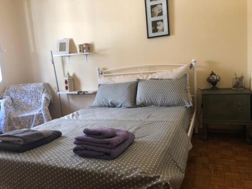 1 dormitorio con 1 cama con 2 toallas en Vintage apartment , 700m from metro, en Atenas