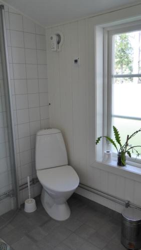 a white bathroom with a toilet and a window at Cottage - Majviken in Ljungskile