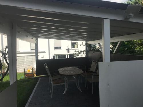 ラーベンスブルクにあるFerienwohnung *stadtnah* ruhig* modernのパティオ(パーゴラの下にテーブルと椅子付)