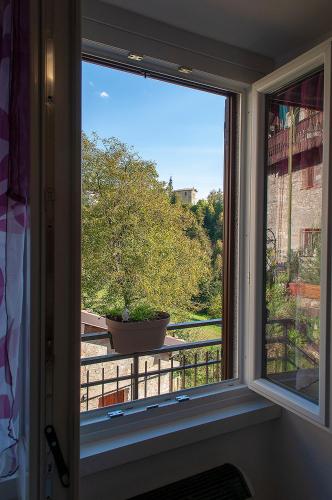 a window with a potted plant on a balcony at Bed &Breakfast Bellavista in San Giovanni Bianco