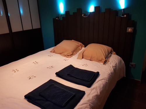 a bed with two towels and two pillows on it at Les Bruyères in Civrieux-dʼAzergues