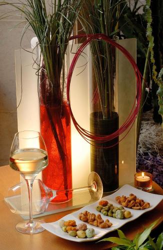 a table with two plates of food and a glass of wine at Mercure Strasbourg Centre in Strasbourg