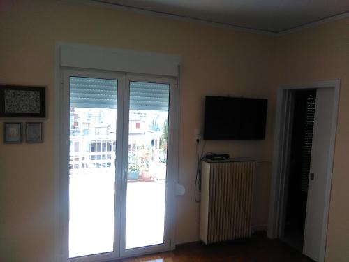 Zimmer mit einer Glasschiebetür und einem TV in der Unterkunft Mia's Atelier, Balcony to Acropolis in Athen