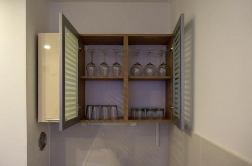 a cabinet with glasses in it on a wall at Apartmani ORION - Sunce in Vinkovci