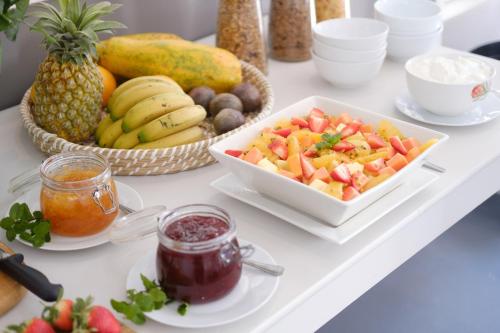 a white table with fruit and a plate of food at Constantia White Lodge Guest House in Cape Town