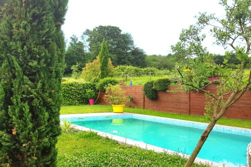 a swimming pool in a yard with a fence at Les Bruyères in Civrieux-dʼAzergues
