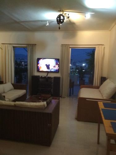 a living room with a couch and a tv at George's Apartment in Athens