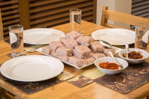 a table with plates and bowls of food on it at Gurubeula Leisure As You Wish in Deniyaya