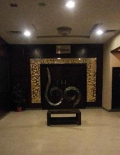 a living room with a fireplace with two large sculptures at Brijwasi Lands Inn in Mathura
