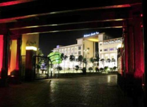 a view of a building at night with lights at Brijwasi Lands Inn in Mathura