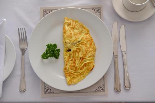 a white plate with a piece of food on a table at Constantia White Lodge Guest House in Cape Town