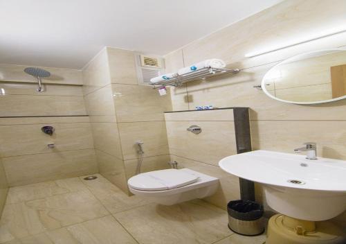 y baño con aseo blanco y lavamanos. en Hotel iStay, en Coimbatore