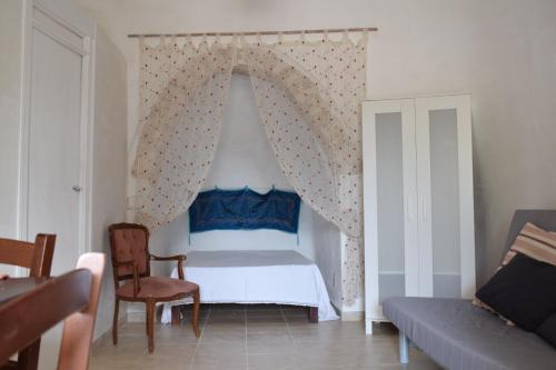 a bedroom with a bed and a chair and a couch at B&B La casa degli artisti in Ostuni