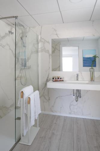 a white bathroom with a sink and a shower at Hotel Alamo in Alicante