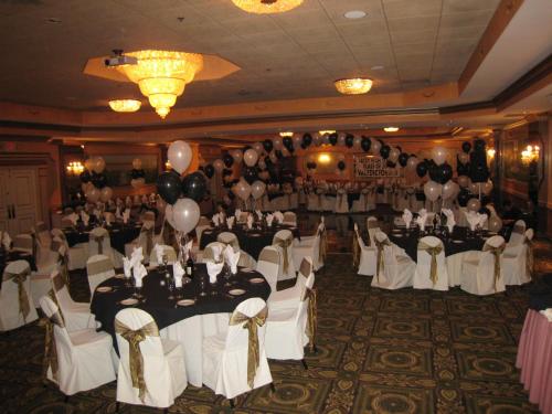 a banquet hall with white tables and balloons at Meadowlands Plaza Hotel in Secaucus