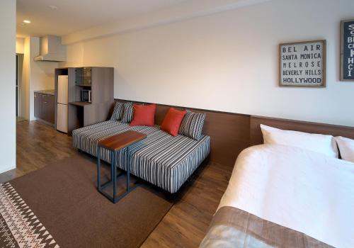 a living room with a couch and a table at e-stay ebisu in Osaka