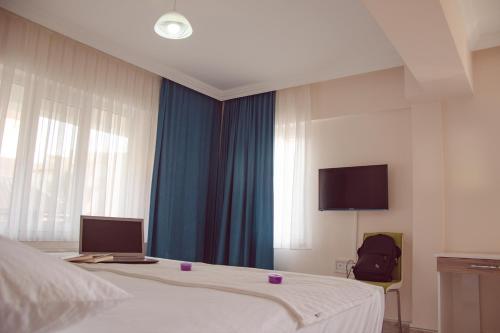 a bedroom with a bed with a laptop on it at Çanakkale Venüs Pansiyon in Canakkale