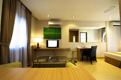 a hotel room with a table and a bed and a desk at De Palma Resort Kuala Selangor in Kuala Selangor