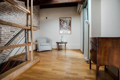 a living room with a staircase and a brick wall at Loft Mirano (Alloggi alla Campana) in Mirano
