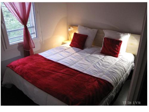 リュス・サン・ソヴァールにあるT2 de L'yseのベッドルーム1室(大型ベッド1台、赤い枕付)