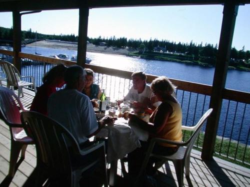a group of people sitting around a table on a deck at Centre de Villégiature Dam-en-Terre in Alma