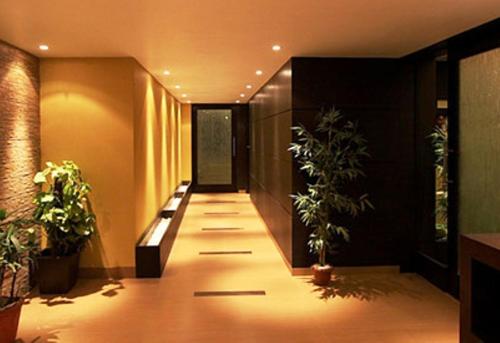 a hallway with potted plants in a building at Brijwasi Royal in Mathura