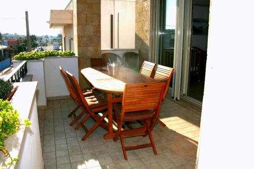 a wooden table and chairs on a balcony at Cuore di mare SALENTO - Beach House for Families in Torre Pali 