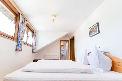 two beds in a room with two windows at Appartement Haus Moser in Sankt Michael im Lungau