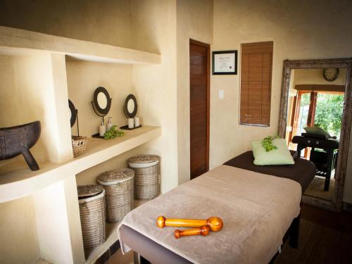 a bedroom with a bed with a wooden bat on it at Nedile Lodge in Welgevonden Game Reserve