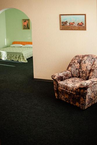 a room with a chair and a bed and a bedroom at Vershnyk in Cherkasy