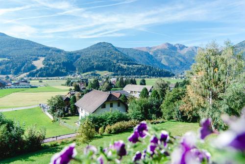 a village in the mountains with purple flowers at Appartement Haus Moser in Sankt Michael im Lungau