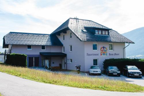 a large white building with cars parked in front of it at Appartement Haus Moser in Sankt Michael im Lungau