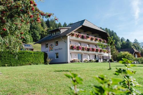 a large white building with flowers on the balcony at Appartement Haus Moser in Sankt Michael im Lungau