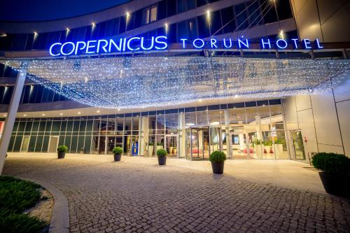 a building with a sign that reads corporateus tour hotel at Copernicus Toruń Hotel in Toruń