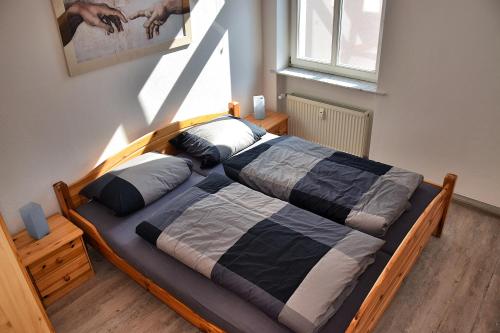 ein Schlafzimmer mit einem Holzbett mit Kissen darauf in der Unterkunft Domfreiheit in Naumburg