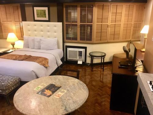 a hotel room with two beds and a table at Lourdes Suites in Manila