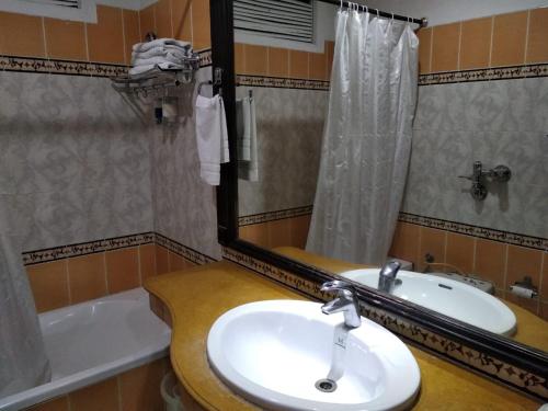 a bathroom with a sink and a mirror and a tub at Hotel City Heart Premium in Chandīgarh
