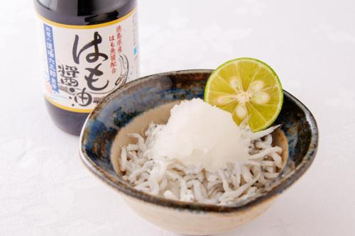 a bowl of noodles with a lime and a bottle of beer at Tokushima Grandvrio Hotel in Tokushima