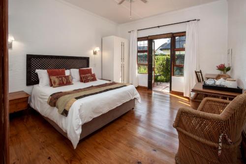 a bedroom with a bed and a desk and a window at House on Westcliff in Hermanus