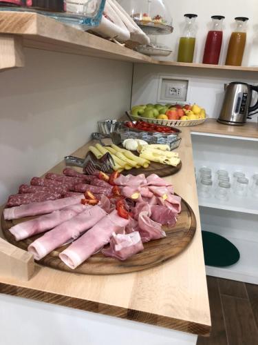 Khome Rooms & Apartment في كاتانيا: صينية من اللحوم والخضار على لوحة التقطيع